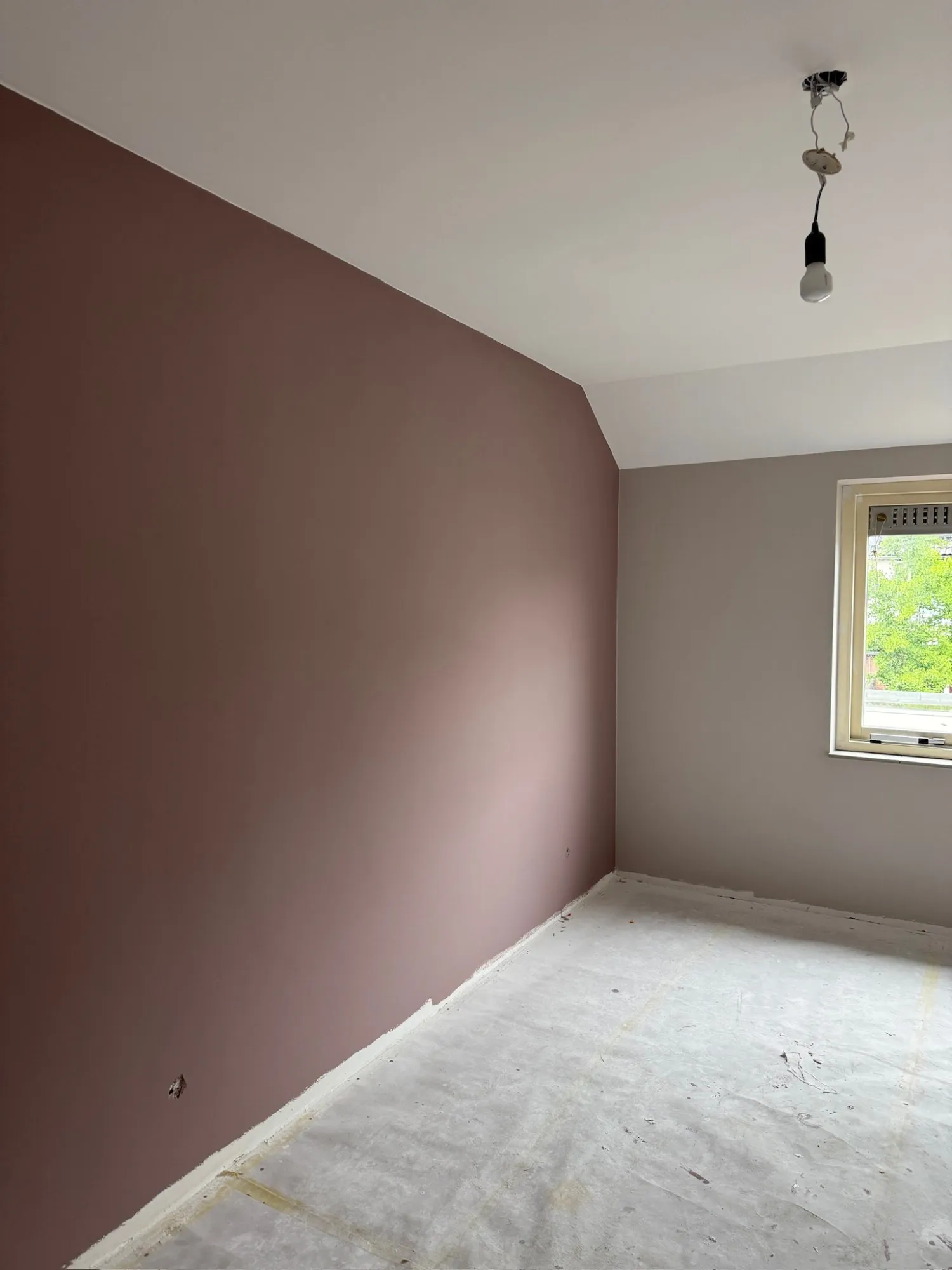 Kamer met een accentwand in oudroze en een strakke lijn tussen wand en plafond
